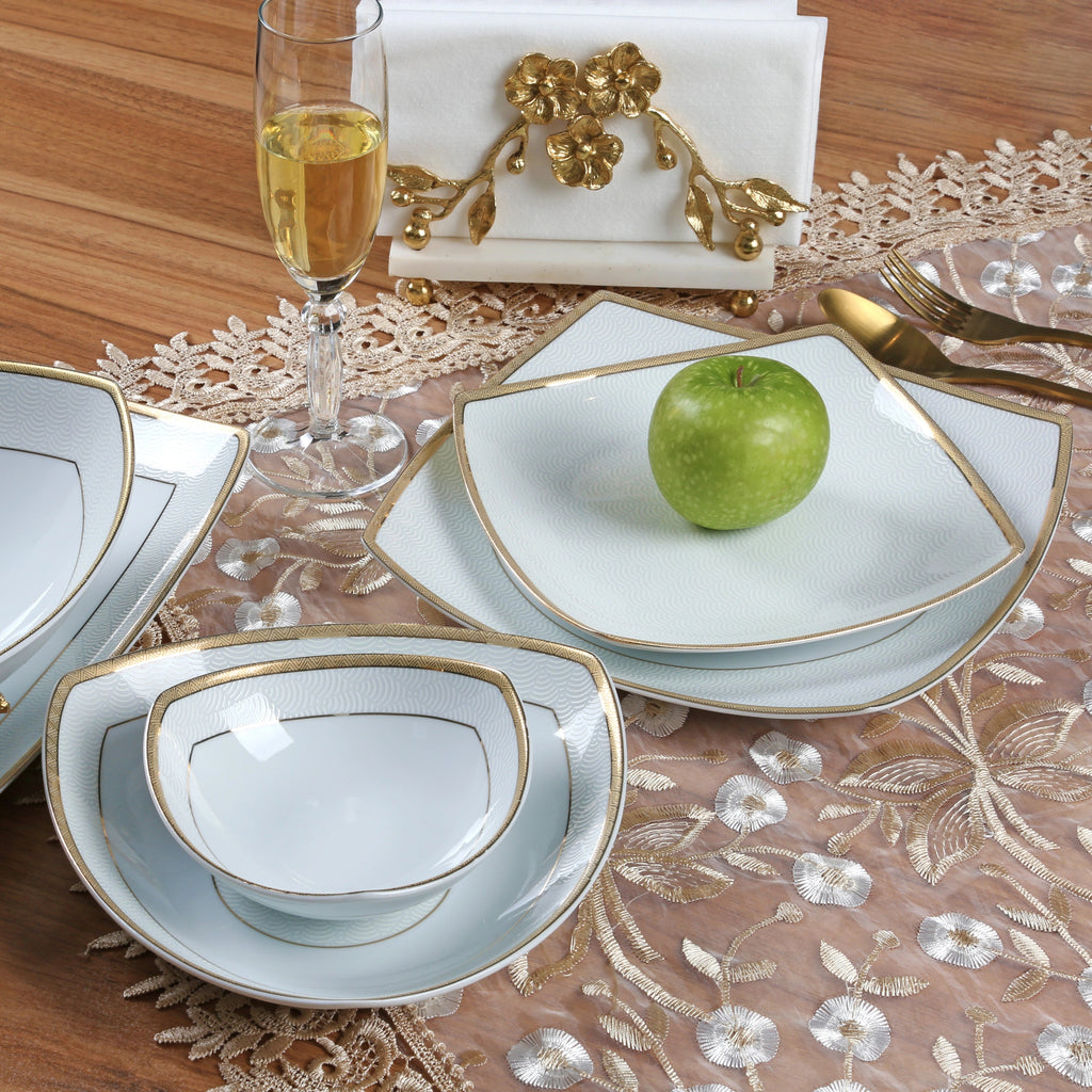 Dining table porcelain setting with white dishes with golden rim