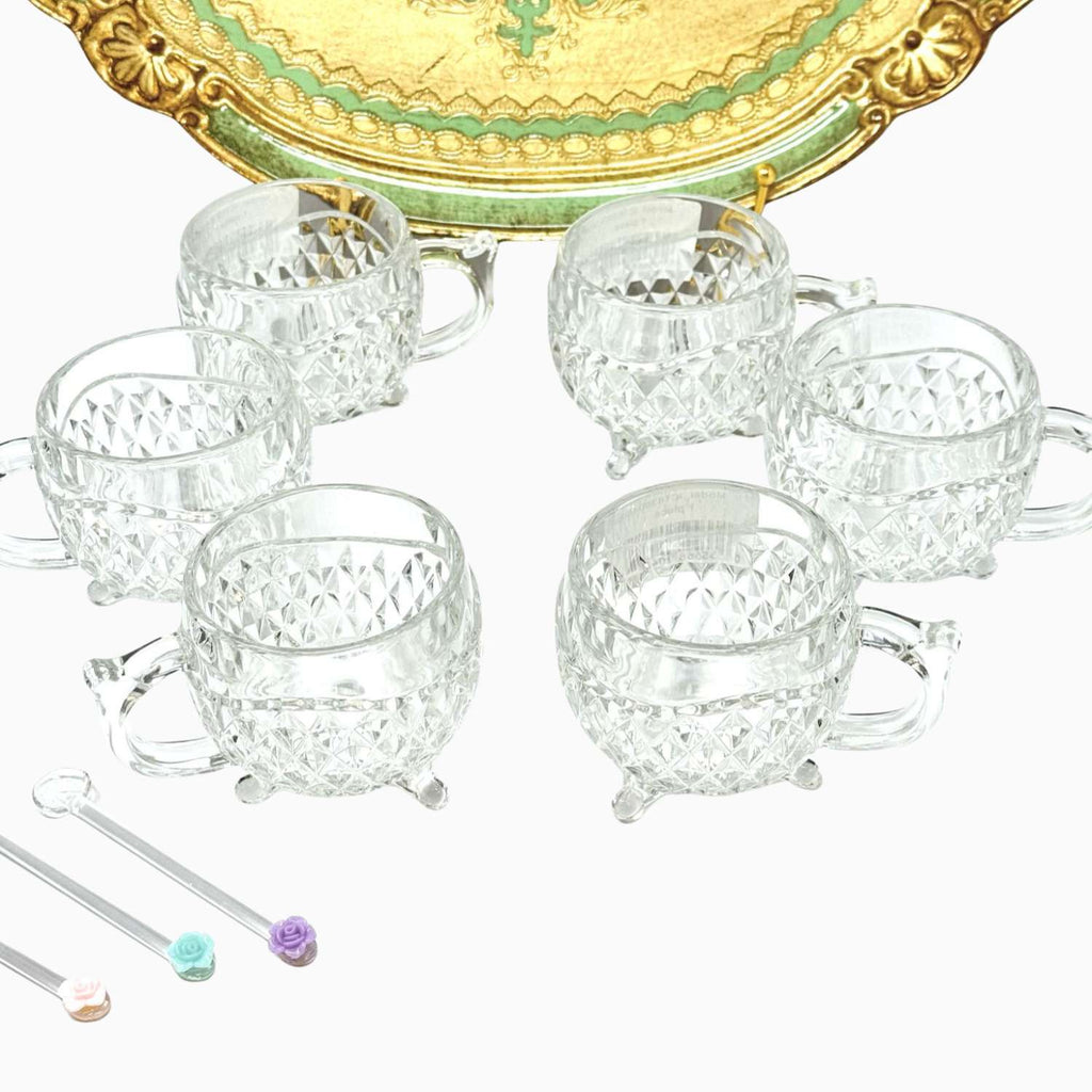 Set of clear glass tea cups with decorative handles on a white background