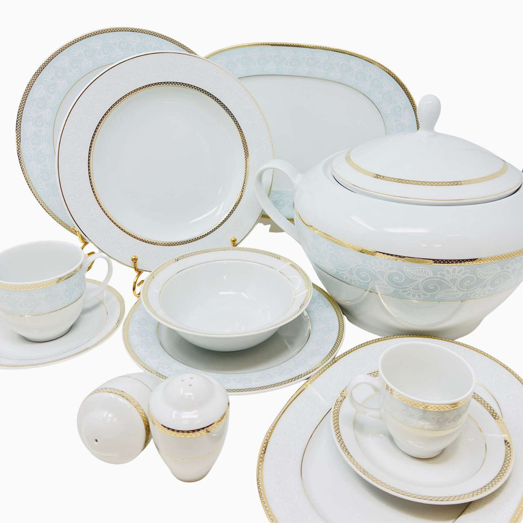 Dining set with white plates, cups, and teapot featuring gold accents on a white background