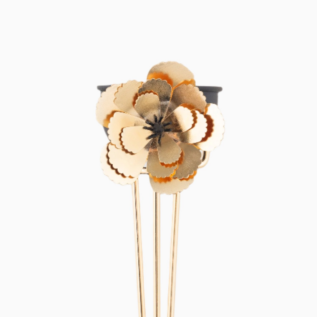 Floral hair clip with gold and beige flowers on a white background