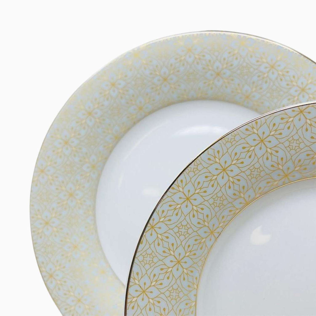 Set of white plates with gold floral patterns on a white background