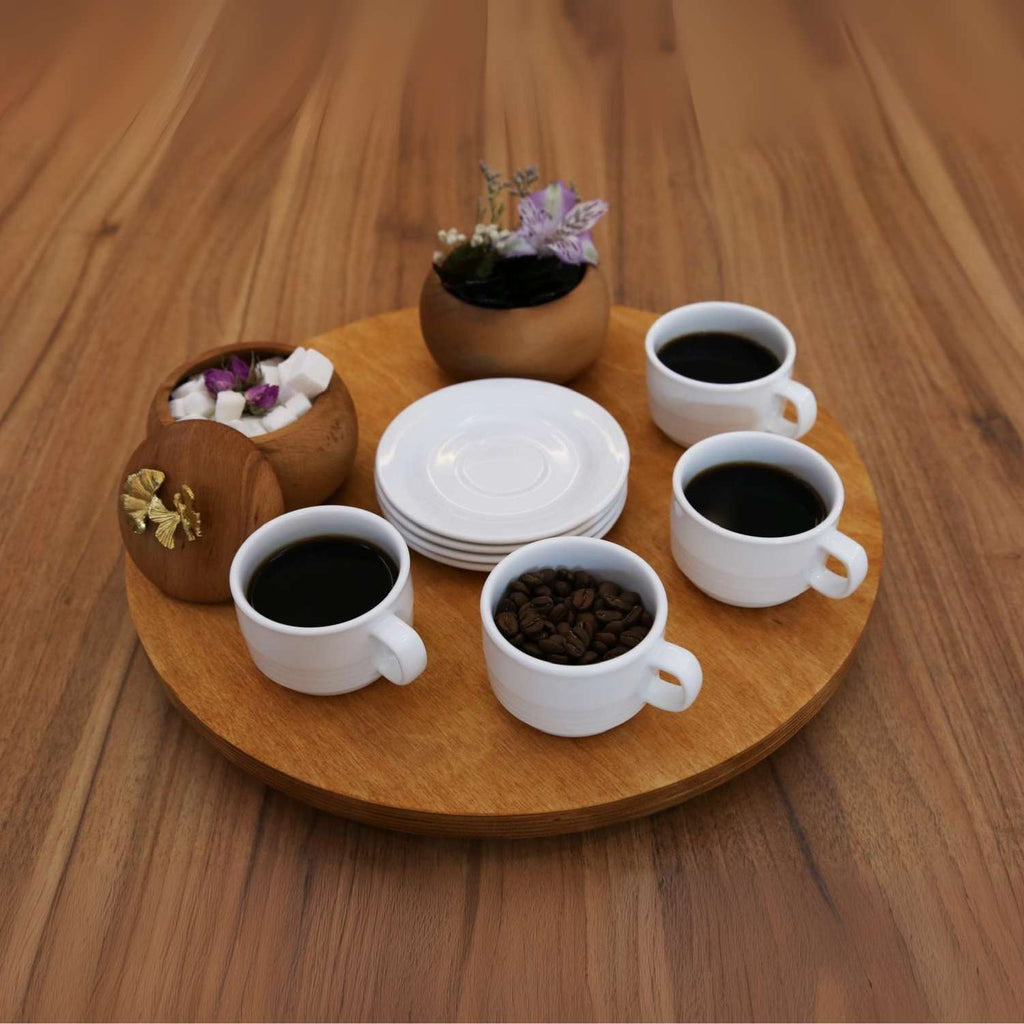 Set of white coffee cups with coffee beans on a wooden tray with decorative elements.