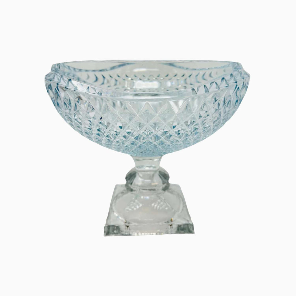 Decorative glass bowl with intricate cut patterns on a white background