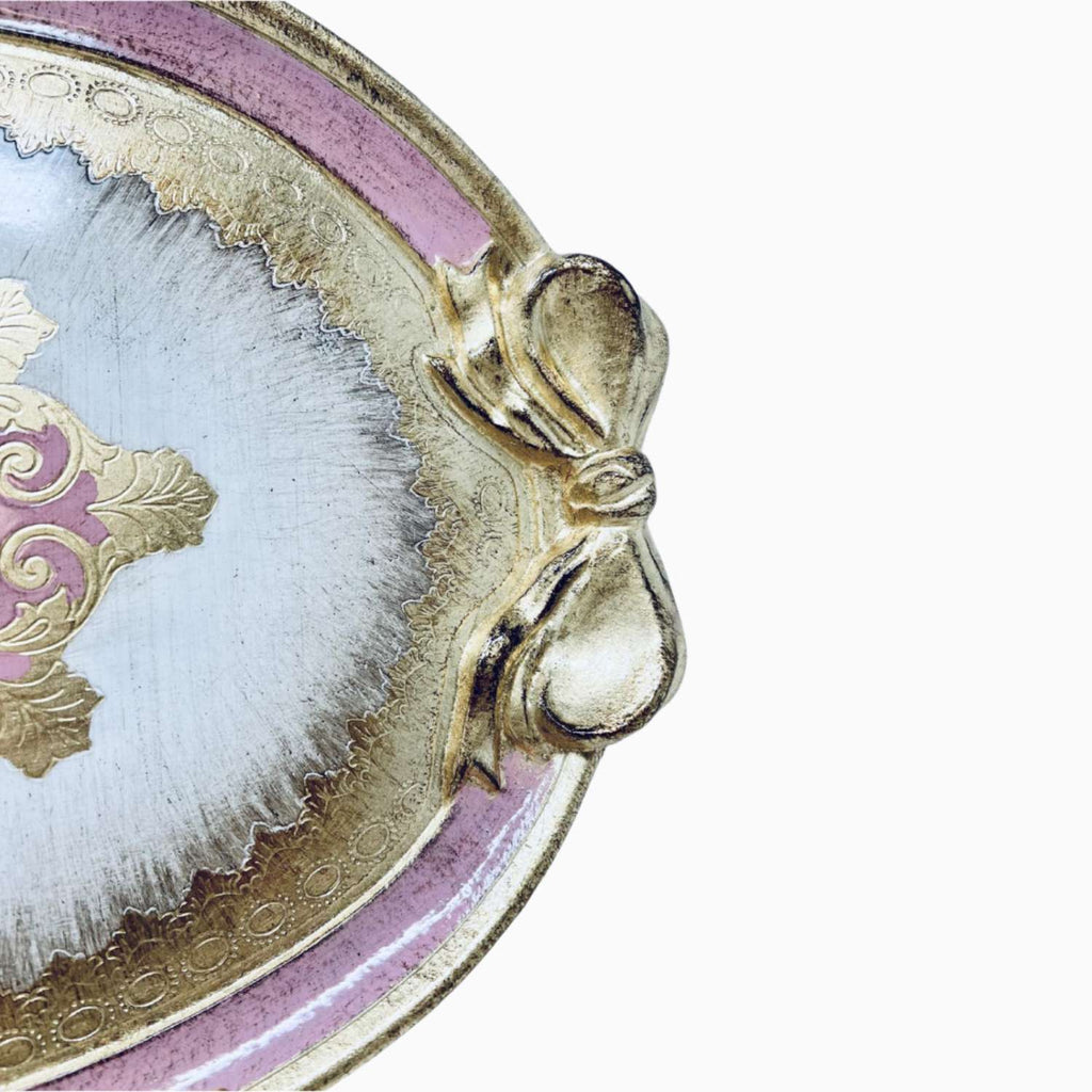 Decorative tray with gold bow and pink rim on a white background