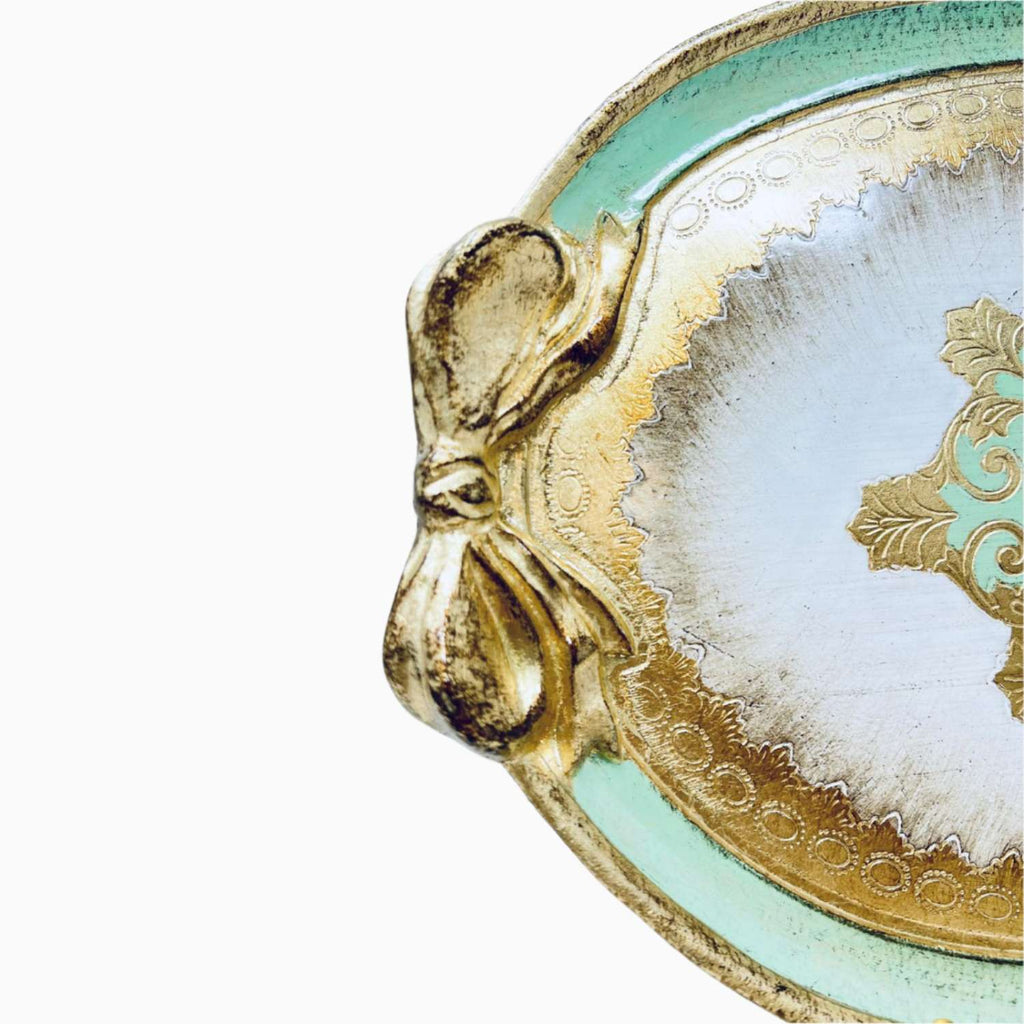 Decorative tray with gold bow and turquoise rim on a white background