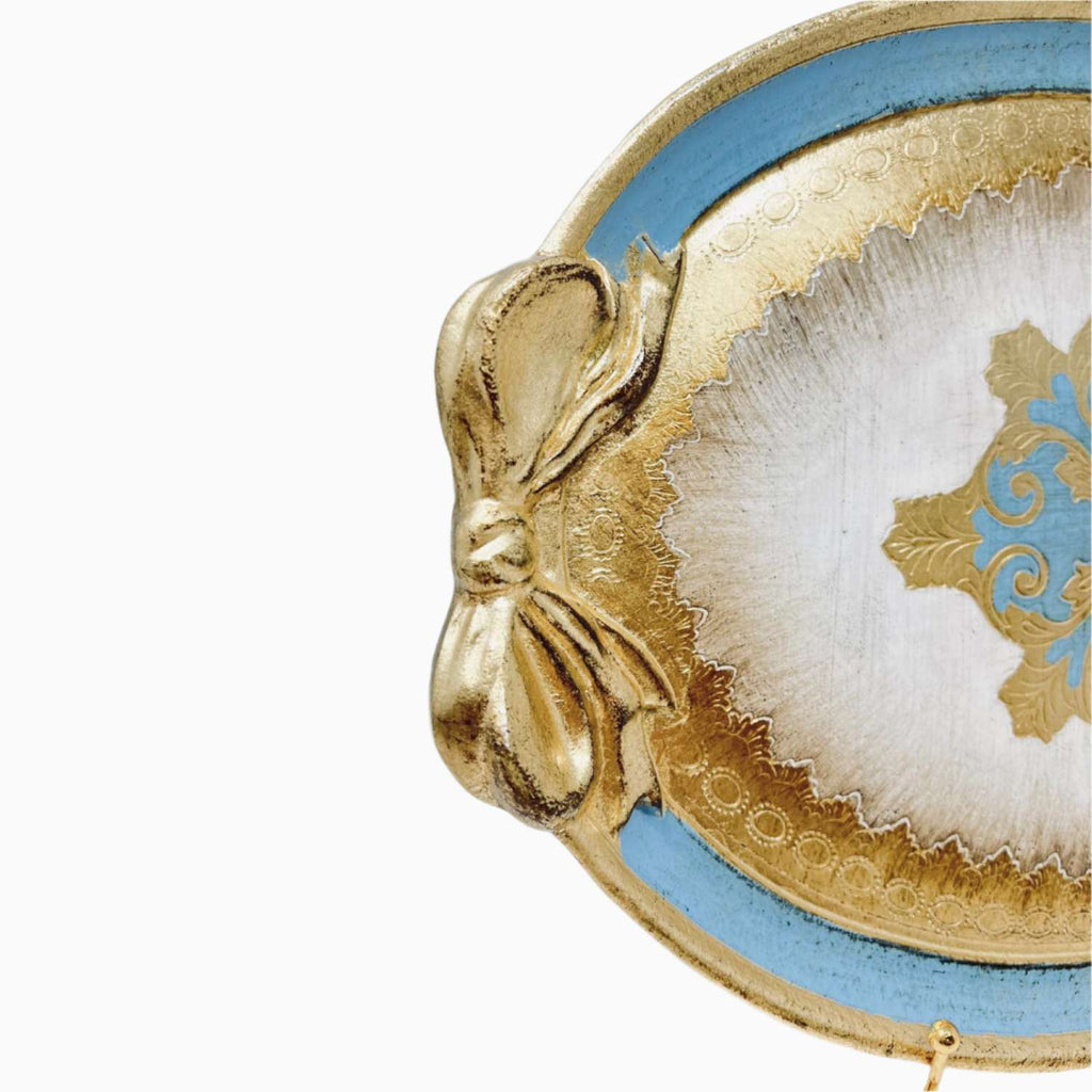 Decorative tray with gold bow and blue and white design on a white background