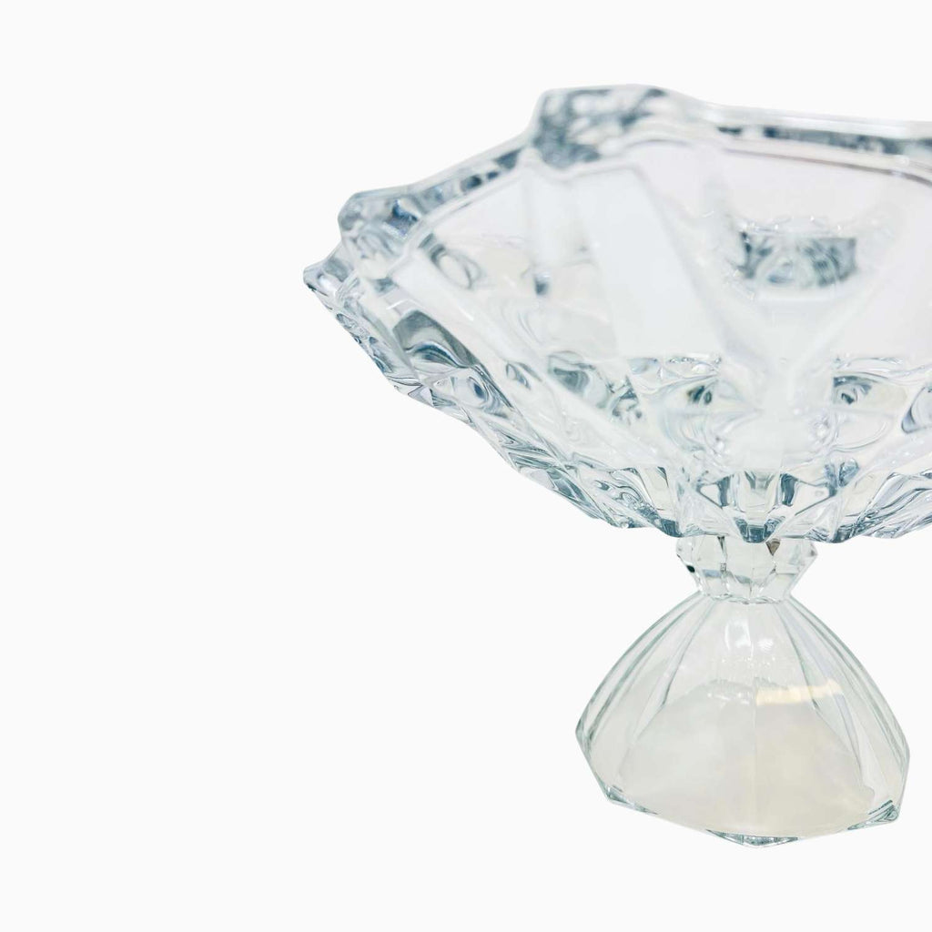 Clear glass candy dish with diamond-shaped top on a white background