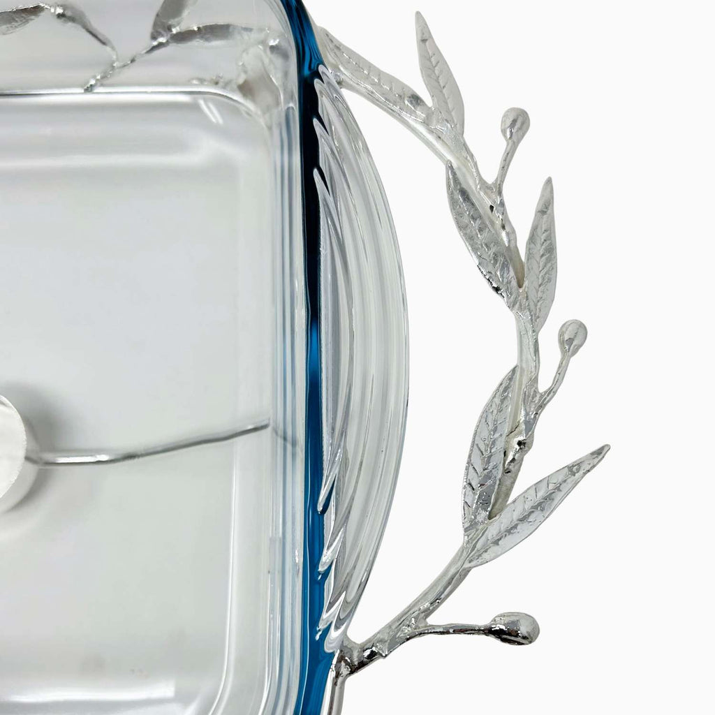 Close-up of a decorative glass item with silver leaf design on a white background