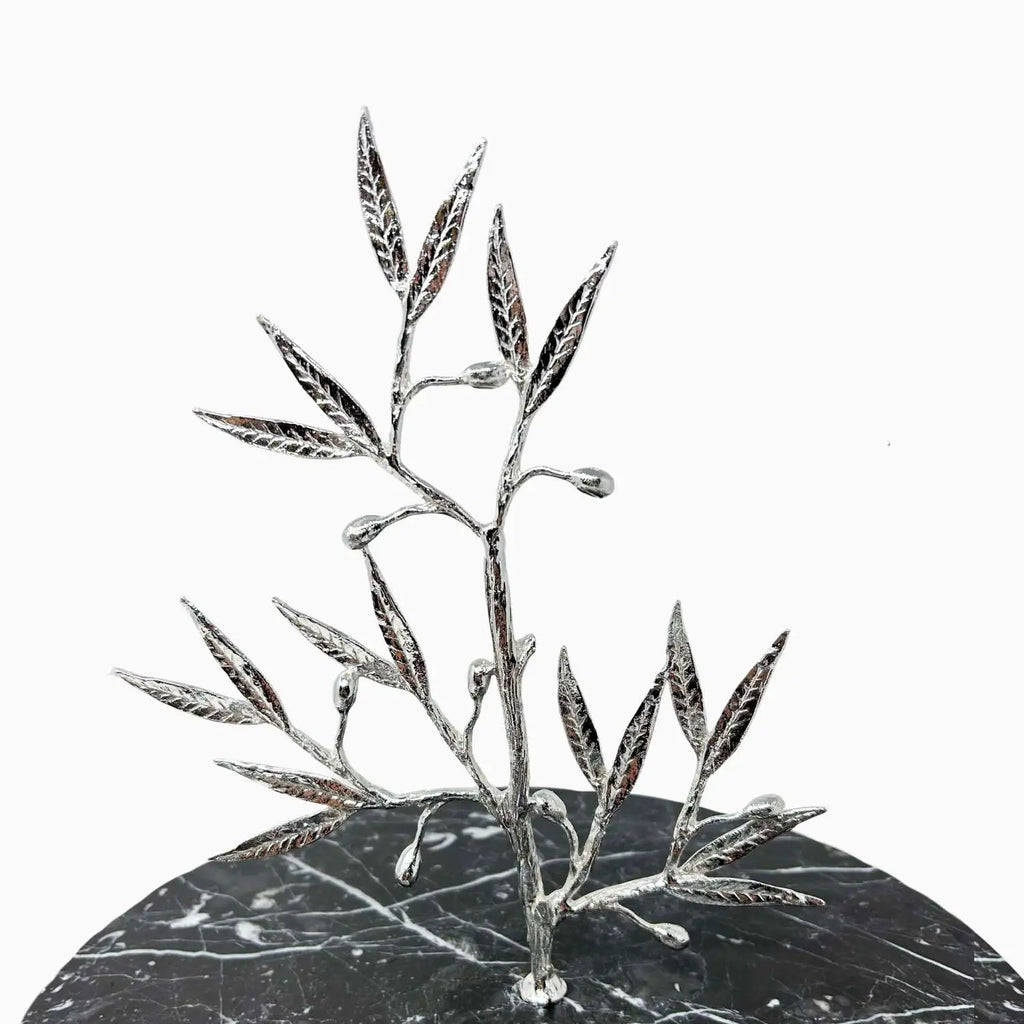 Silver leaf branch on a black marble base with a white background