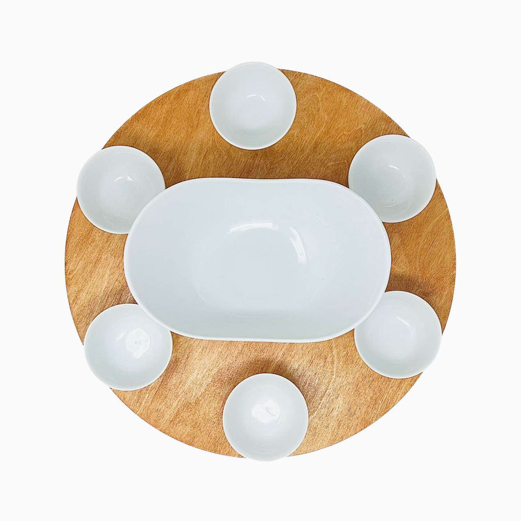 Wooden tray with a central oval bowl and six smaller round bowls on a white background