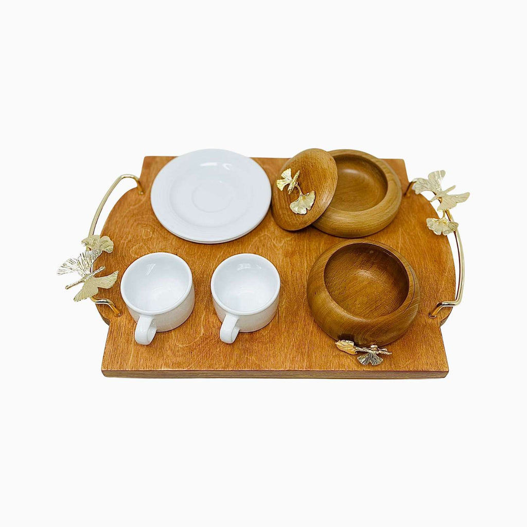 Wooden tray with ceramic and wooden bowls and cups on a white background