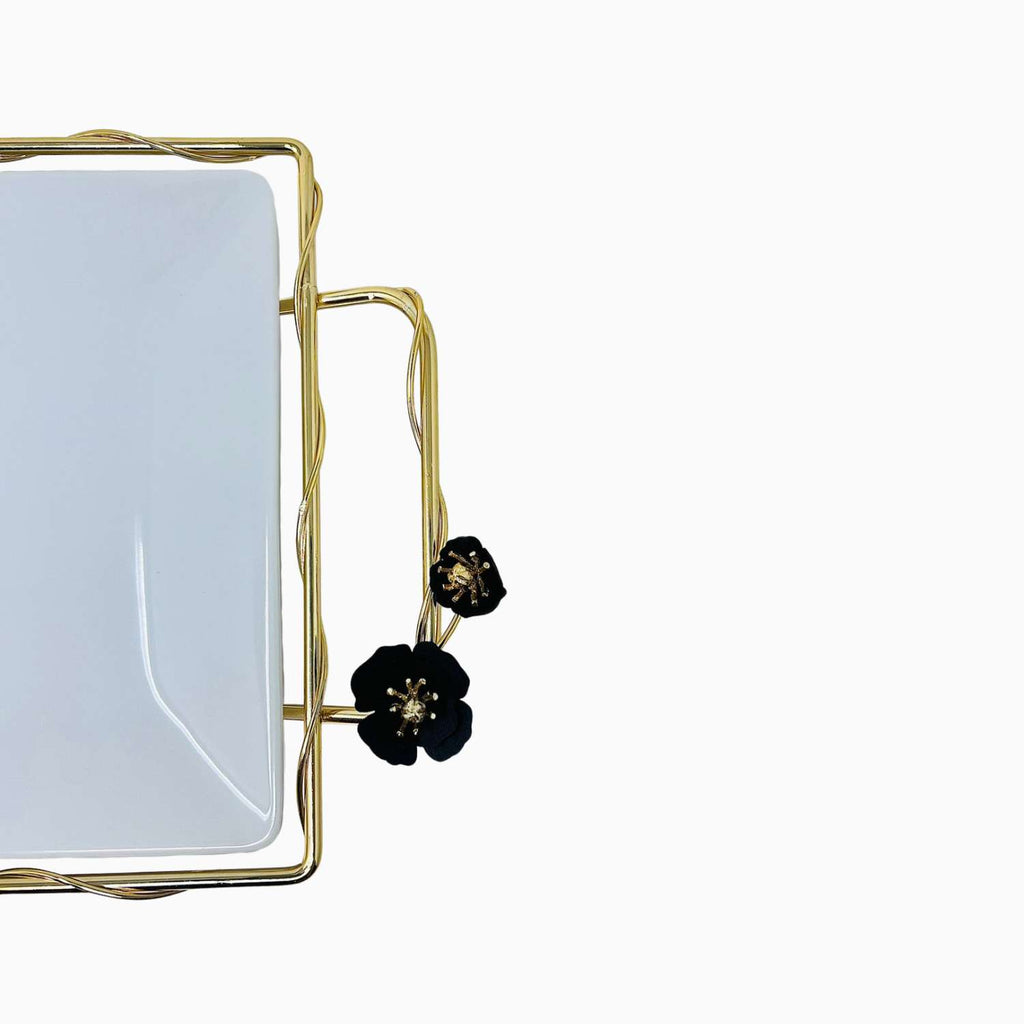 Rectangular serving plate with gold frame and black floral accents on a white background