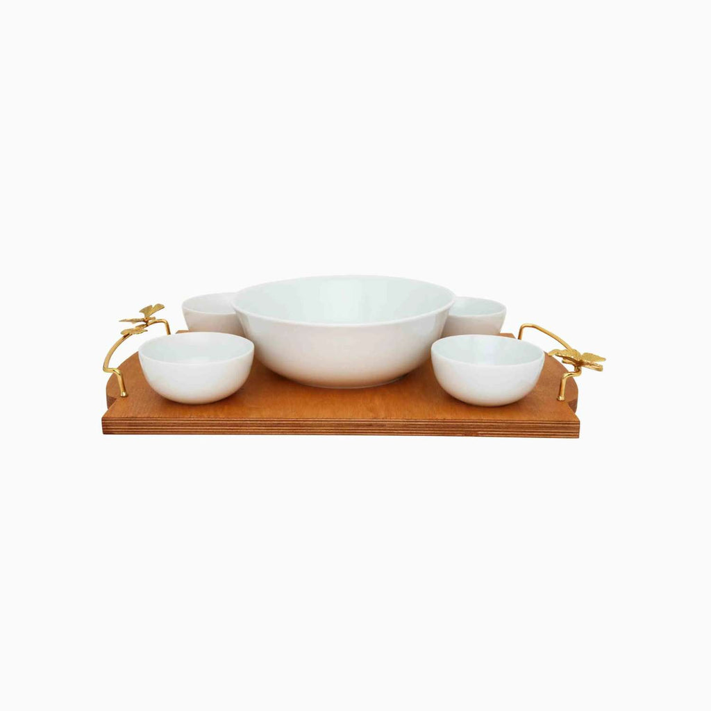 Set of white ceramic bowls on a wooden tray with gold accents on a white background