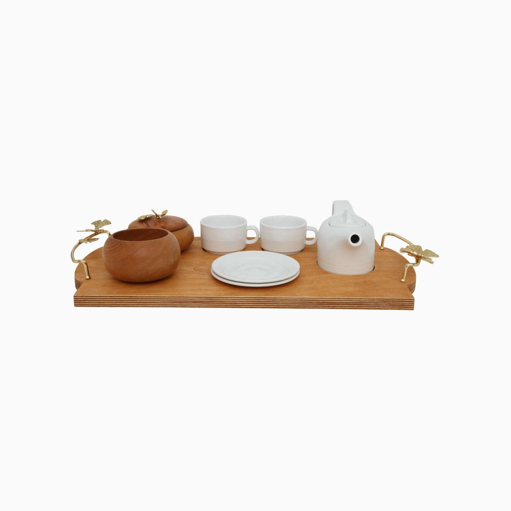 Tea set with wooden teapot, ceramic cups, and saucer on a wooden tray.